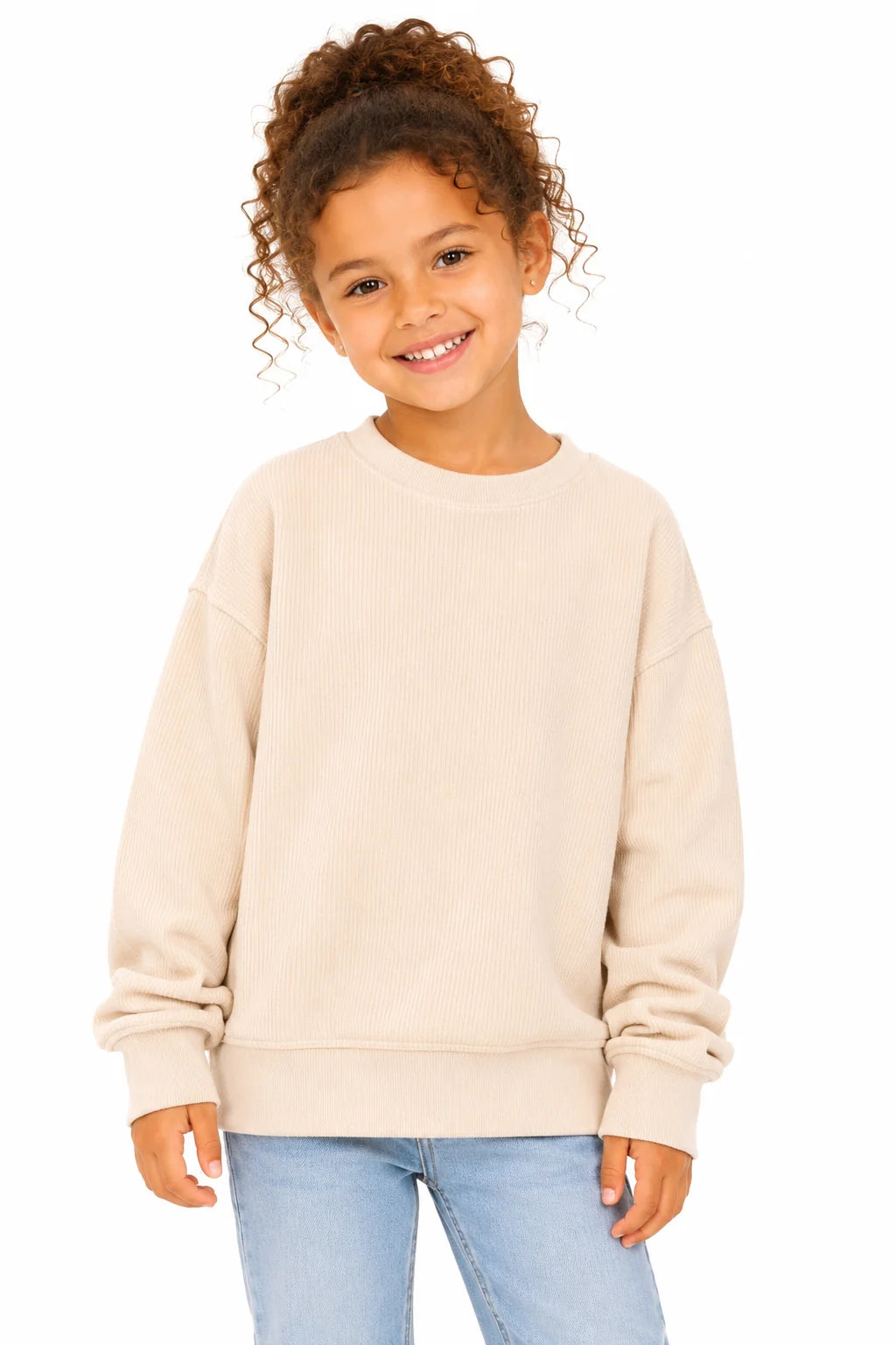 Child wearing a beige sweatshirt and blue jeans on a white background