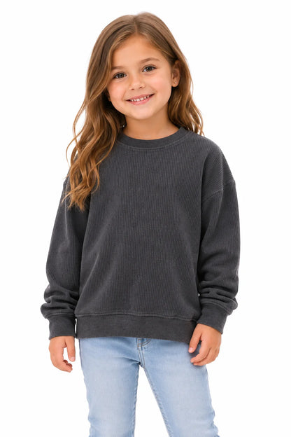 Young girl wearing a dark gray sweatshirt and light blue jeans on a white background