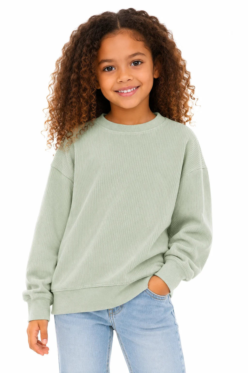 Young girl wearing a light green sweater and blue jeans on a white background